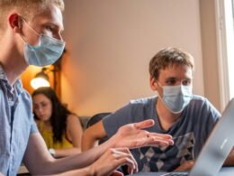 Mann mit grauem T-Shirt und weißer Gesichtsmaske als Beispiel für Hygienemaßnahmen in öffentlichen Bereichen