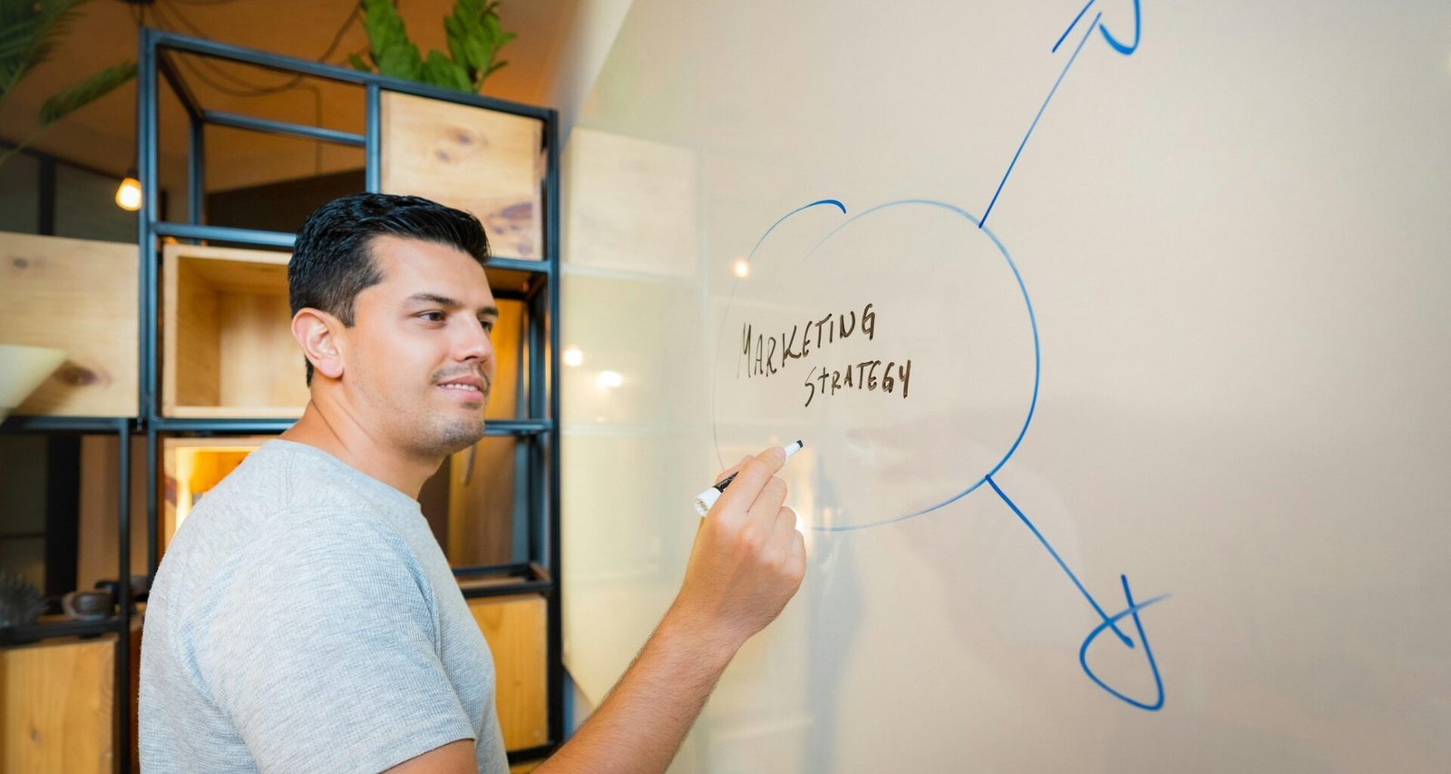 Mann in grauem T-Shirt steht aufrecht vor einer weißen Wand. Neutrale Darstellung für technologische Fachartikel.