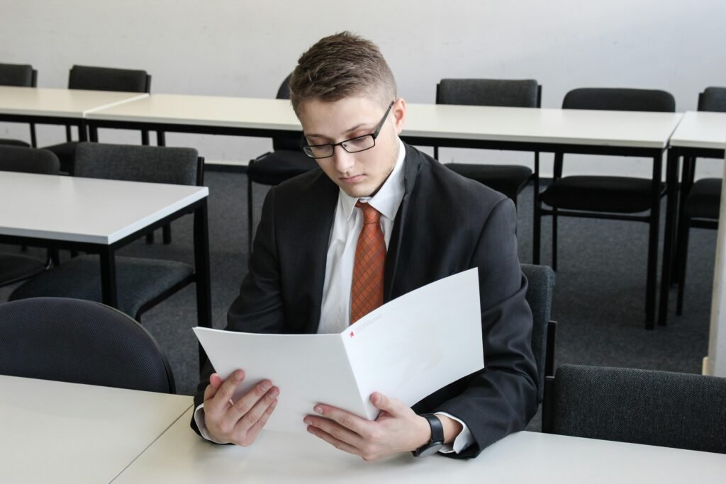 Ein Mann steht in einem leeren Raum und hält einen Ordner in den Händen, Fokus auf Raum und Dokumente.