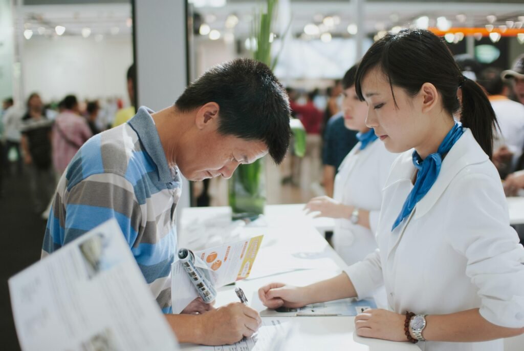 Ein Mann unterschreibt ein Dokument an einem Service-Counter, ideal zur Illustration von Vertragsabschlüssen und Serviceprozessen.