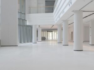 Heller Innenraum mit weißen Säulen und großen Fenstern in moderner Architektur, aufgenommen bei Tageslicht