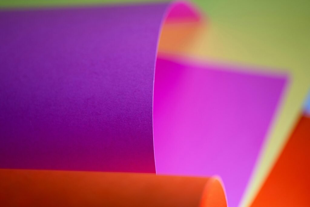 Eine Rolle farbiges Papier aus der Nähe fotografiert, das mehrere Farbnuancen zeigt und kreative Möglichkeiten symbolisiert.