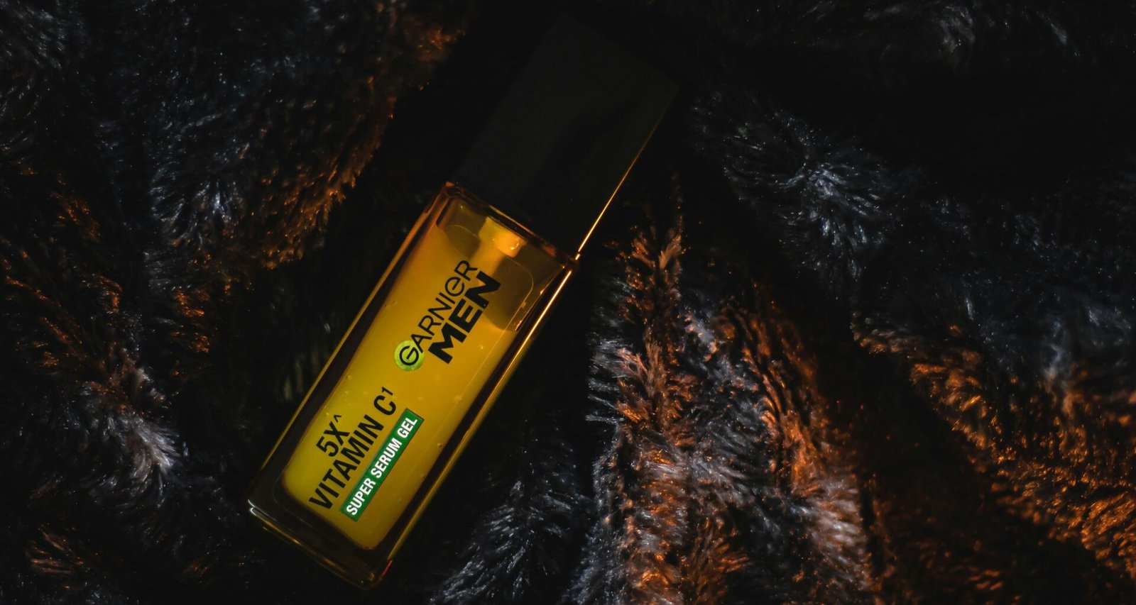 Eine einzelne Flasche steht auf einer hellen, fellartigen Oberfläche, im Vordergrund scharf abgebildet, Hintergrund unscharf