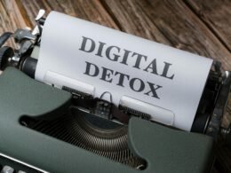 Nahaufnahme einer Schreibmaschine mit Papier, auf dem Digital Detox steht – Symbol für bewusste Offline-Pausen im digitalen Alltag