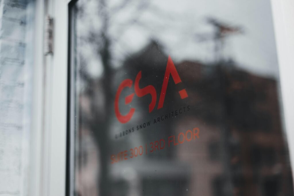 Nahaufnahme eines Fensters, durch das unscharf ein großes Gebäude im Hintergrund zu sehen ist