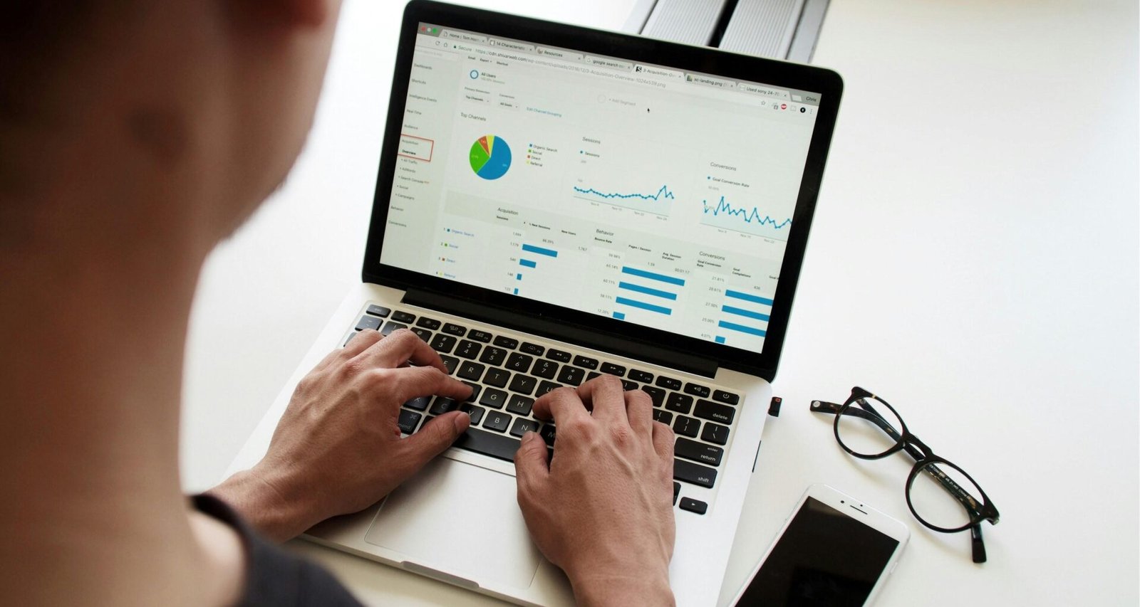 Person arbeitet konzentriert an einem MacBook Pro und nutzt digitale Tools für produktives Arbeiten im modernen Büro.