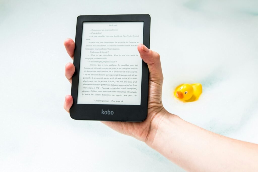 Person hält einen eingeschalteten Amazon Kindle E-Reader in der Hand, geeignet zur Veranschaulichung digitaler Leselösungen