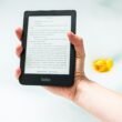 Person hält einen eingeschalteten Amazon Kindle E-Reader in der Hand, geeignet zur Veranschaulichung digitaler Leselösungen