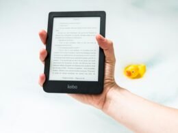 Person hält einen eingeschalteten Amazon Kindle E-Reader in der Hand, geeignet zur Veranschaulichung digitaler Leselösungen