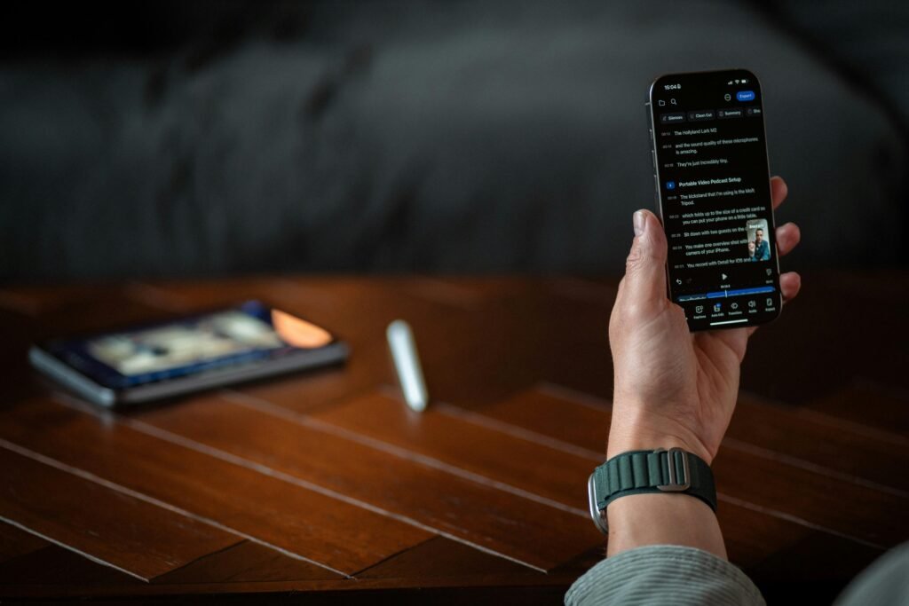 Eine Person hält ein Smartphone mit ausgeschaltetem oder dunklem Bildschirm in der Hand, Fokus auf moderne mobile Technologien.