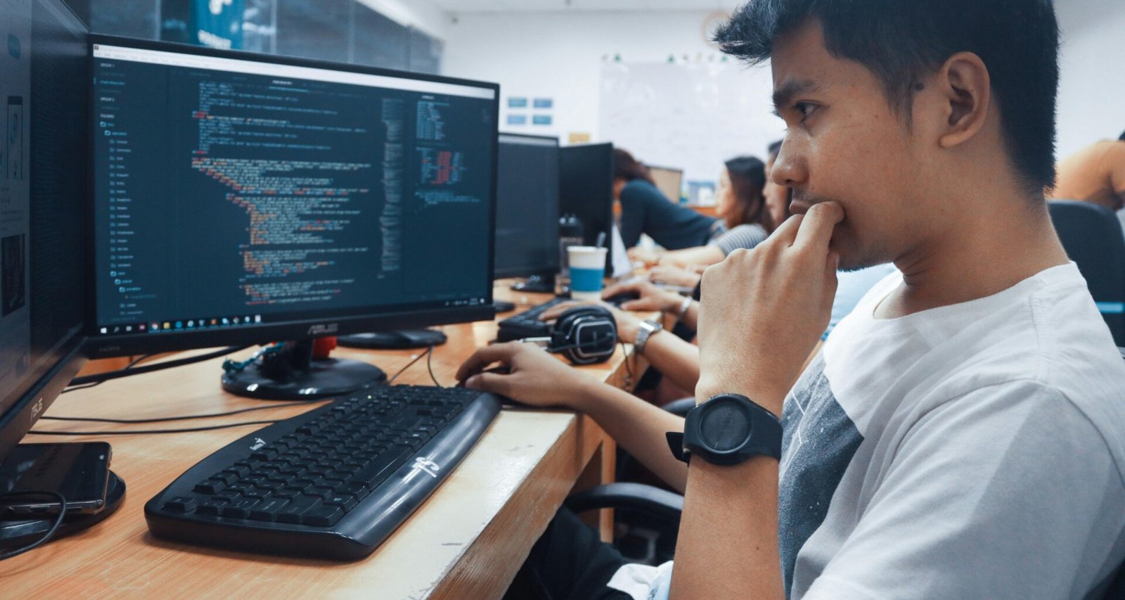Eine Person hält eine Computermaus in einem Raum mit neutraler Einrichtung, geeignet für Themen zu Technologie oder Arbeitsumfeldern.