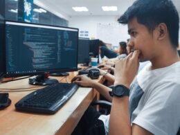 Eine Person hält eine Computermaus in einem Raum mit neutraler Einrichtung, geeignet für Themen zu Technologie oder Arbeitsumfeldern.