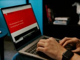 Eine Person sitzt in einem Raum und hält einen Laptop-Computer, dargestellt in einer zeitgemäßen Arbeitsumgebung.