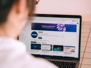 Eine Person sitzt vor einem Laptop und schaut sich einen YouTube-Kanal an, typische Nutzung digitaler Medieninhalte.