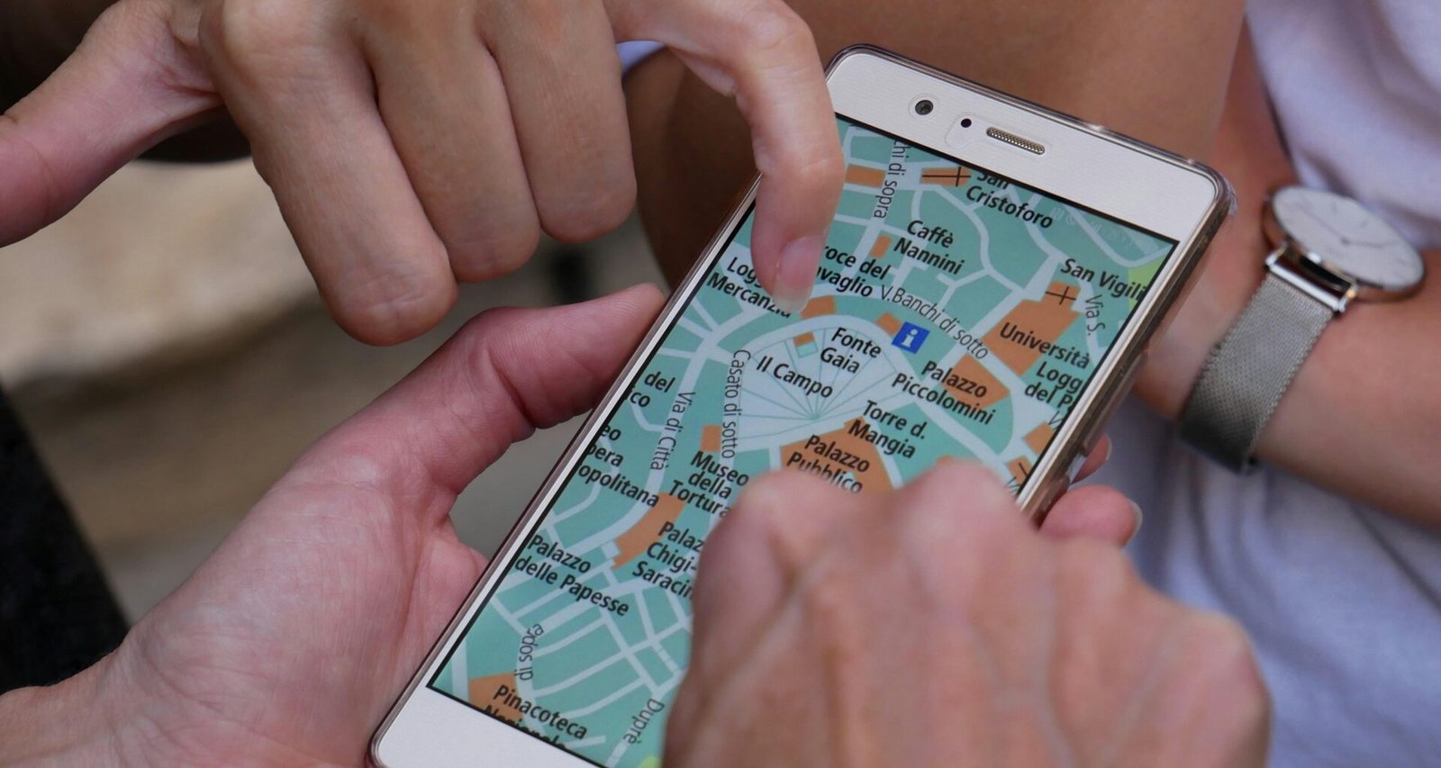 Nahaufnahme einer Hand, die ein Smartphone berührt, Symbol für mobile Technologien und digitale Kommunikation.