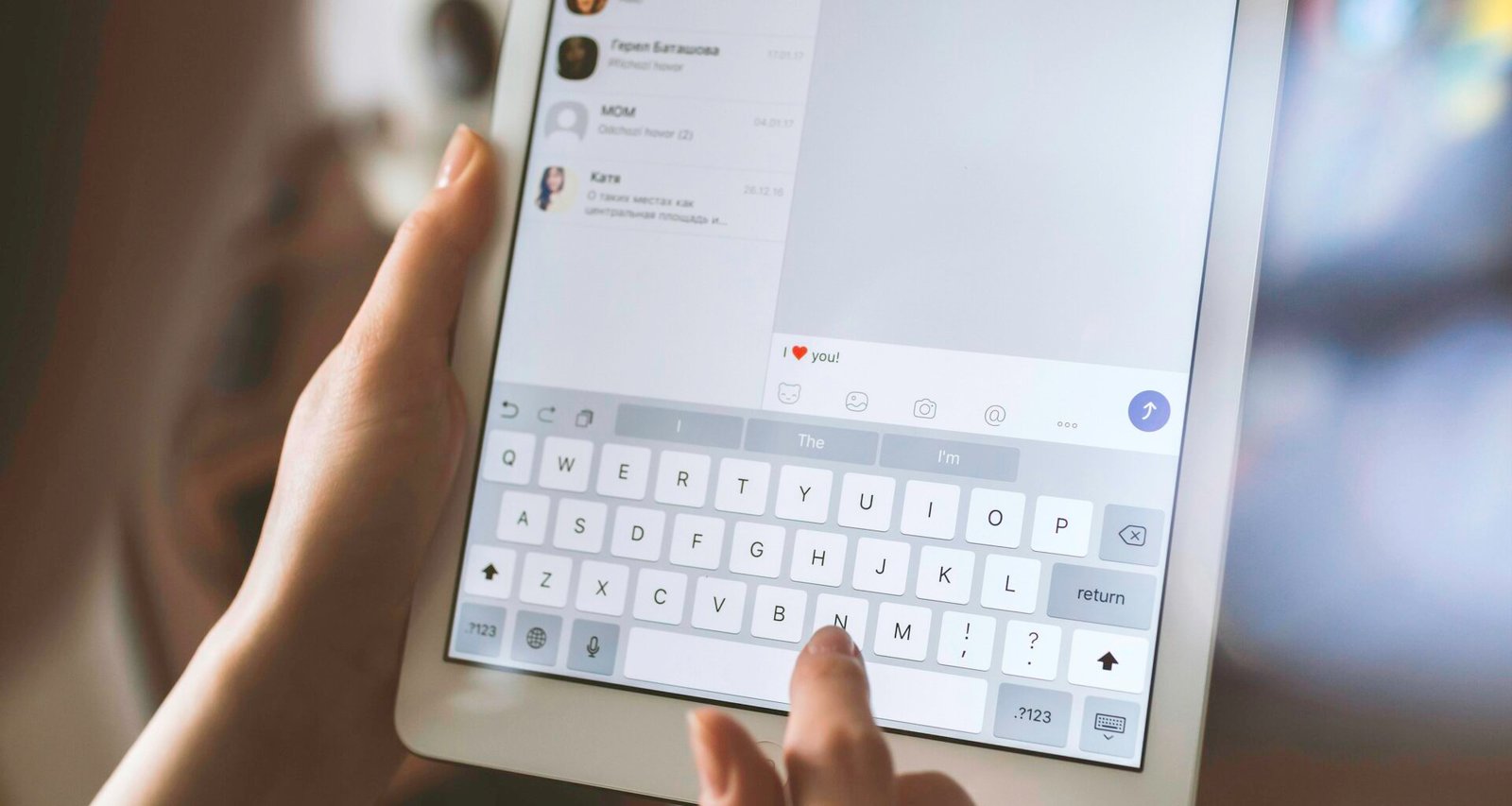 Eine Person bedient ein weißes iPad auf einem Tisch – Fokus auf moderne Technologie und digitales Arbeiten.