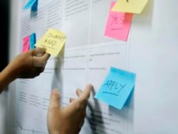 Eine Person hält mehrere gelbe Haftnotizen in der Hand, ideal für die Organisation im Büro oder beim Brainstorming.