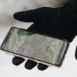 Eine Person hält ein iPhone 6 mit schützender Hülle, Fokus auf Smartphone-Nutzung im Alltag.