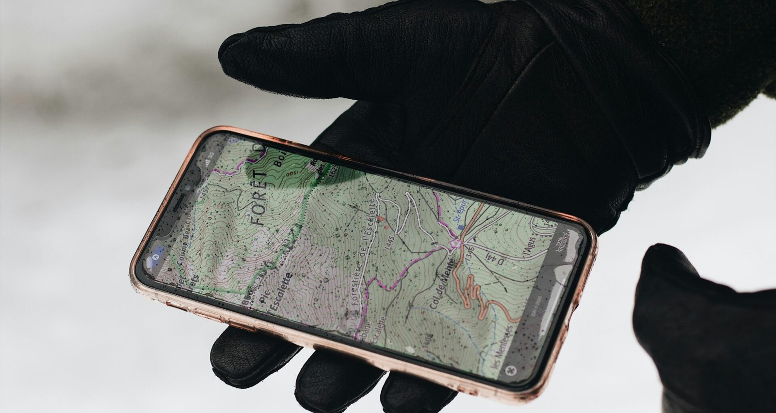Person hält ein iPhone 6 mit schwarzer Schutzhülle in der Hand, Fokus auf das Smartphone und dessen Nutzung.