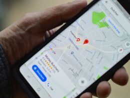 Person hält ein schwarzes Smartphone in der Hand, Fokus auf die mobile Nutzung moderner Endgeräte.