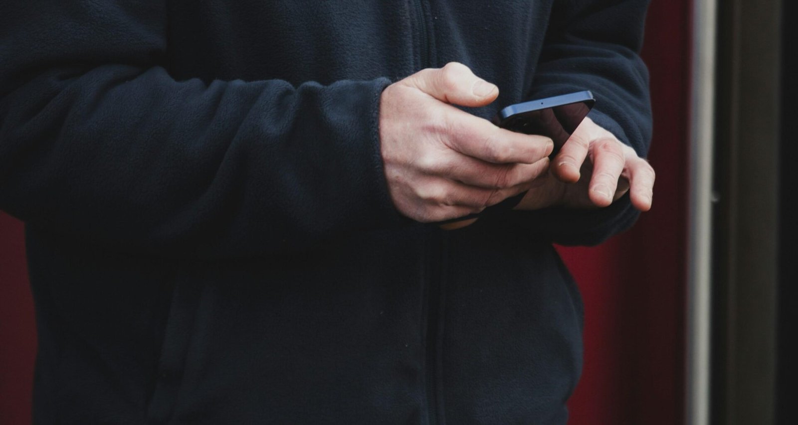 Nahaufnahme von Händen, die ein Smartphone halten, als Symbol für mobile Kommunikation und moderne Technologie