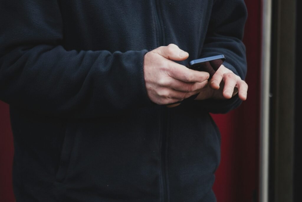 Zwei Hände halten ein Smartphone, bereit für den Einsatz im digitalen Alltag, fotografiert von atelierbyvineeth