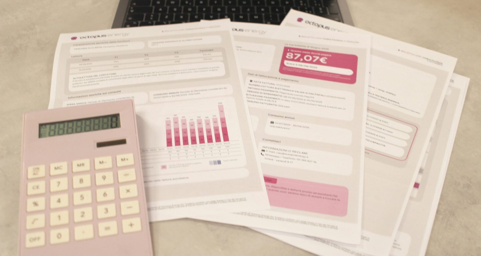 Ein Laptop, ein Taschenrechner und verschiedene Rechnungen liegen auf einem Schreibtisch und veranschaulichen laufende Finanzaufgaben.