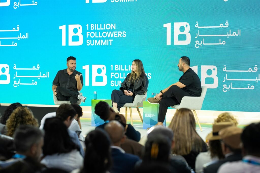 Speaker stehen auf einer großen Bühne beim 1 Billion Followers Summit und diskutieren vor Publikum über Online-Marketing.