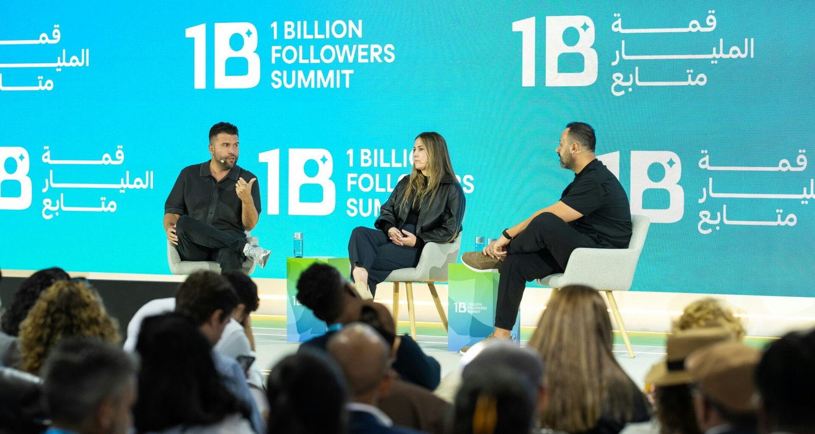 Speaker stehen auf einer großen Bühne beim 1 Billion Followers Summit und diskutieren vor Publikum über Online-Marketing.