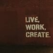 Rote Backsteinwand mit weißem Graffiti-Zitat live, work, create. als Inspiration für Arbeits- und Kreativräume.