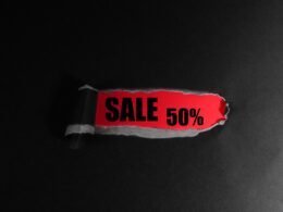 Rotes Rabatt-Schild mit weißem ‚Sale 50%‘-Text auf schwarzem Hintergrund, geeignet für Themen zu Online-Shopping oder Marketingaktionen.