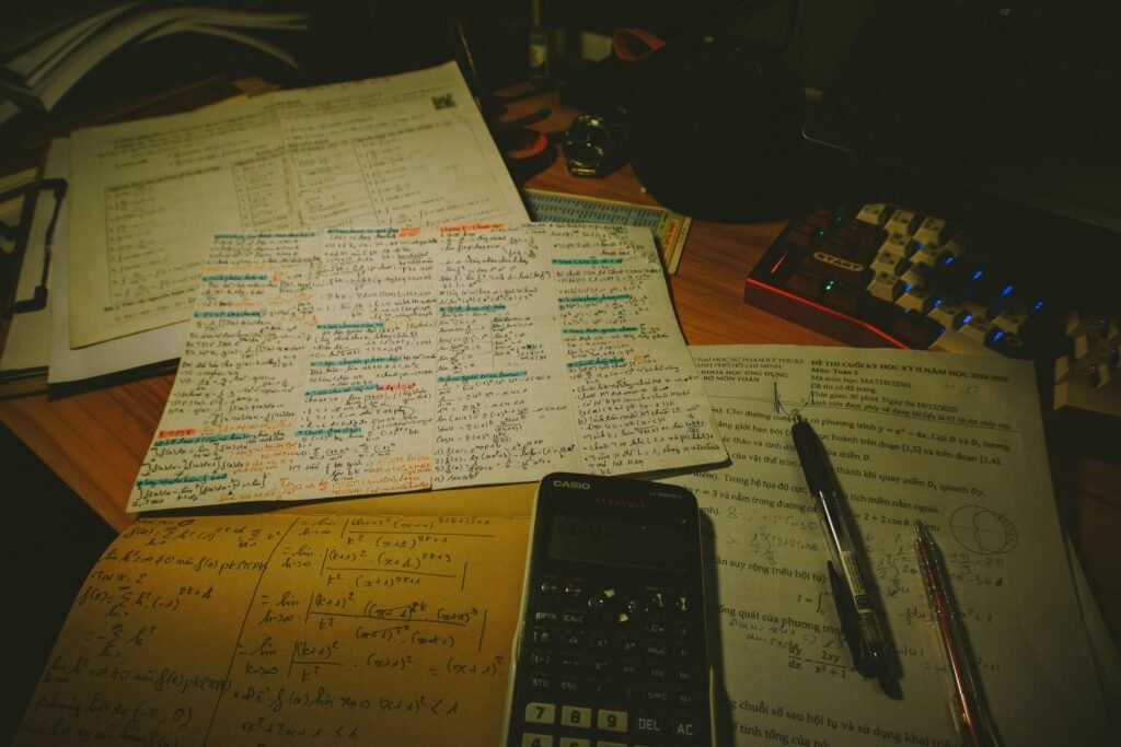 Schreibtisch mit ordentlich verteilten Papieren, Taschenrechner und mehreren Stiften, geeignet für Büroarbeiten und Organisation.