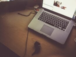 Schwarzer und grauer Laptop in einer Großaufnahme mit sichtbarer Tastatur und Display, Fokus auf technische Details