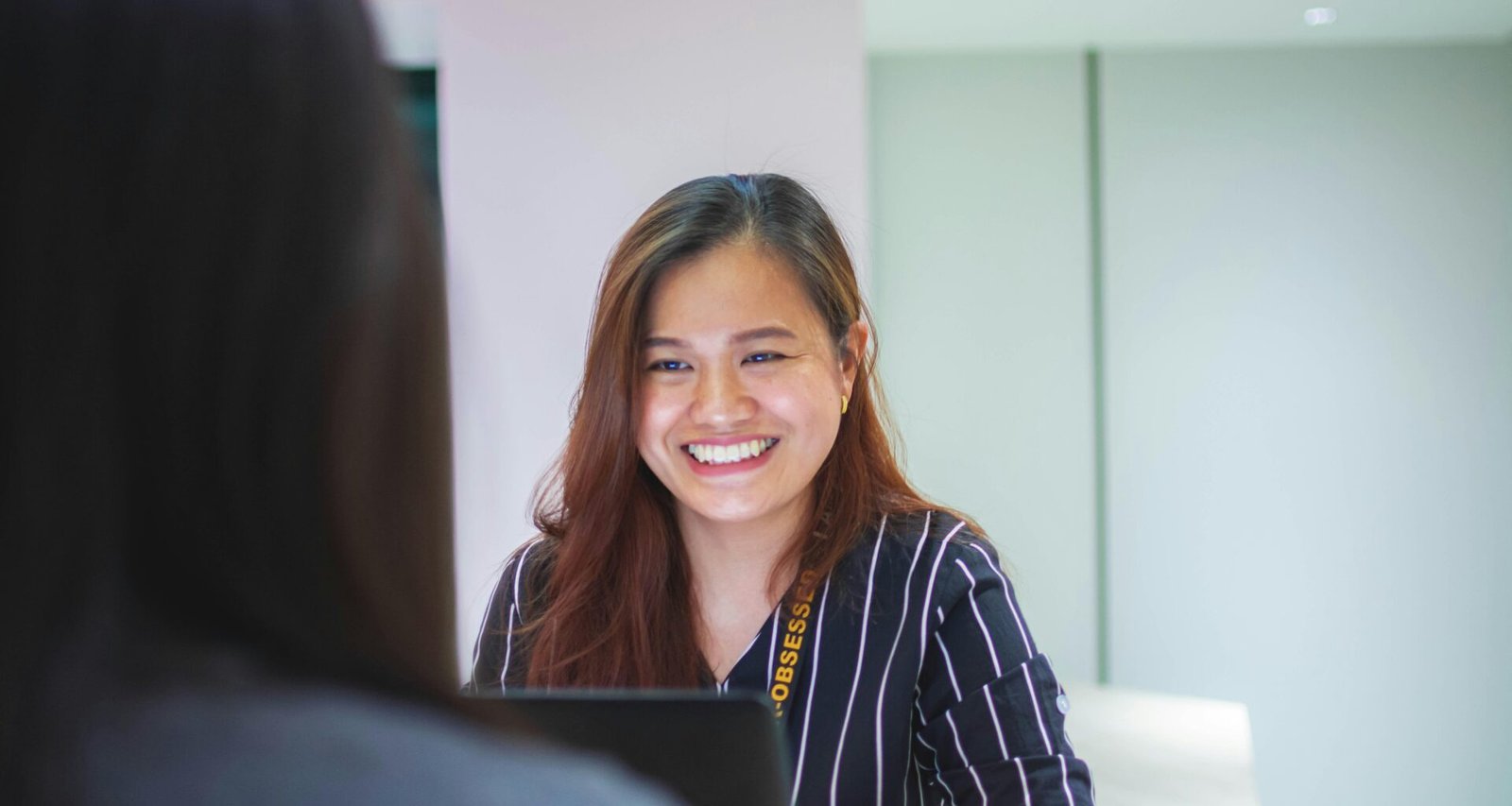 Frau trägt ein schwarz-weiß gestreiftes Oberteil, ideal als modisches Statement im Alltag oder Büro.
