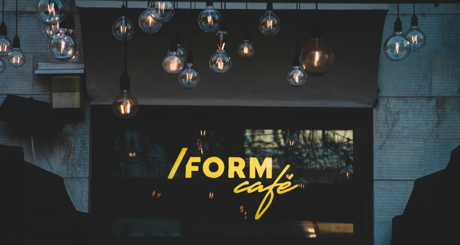 Mehrere schwarz-weiße Pendelleuchten hängen von der Decke in einem modernen, schlichten Raum.