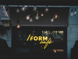 Mehrere schwarz-weiße Pendelleuchten hängen von der Decke in einem modernen, schlichten Raum.