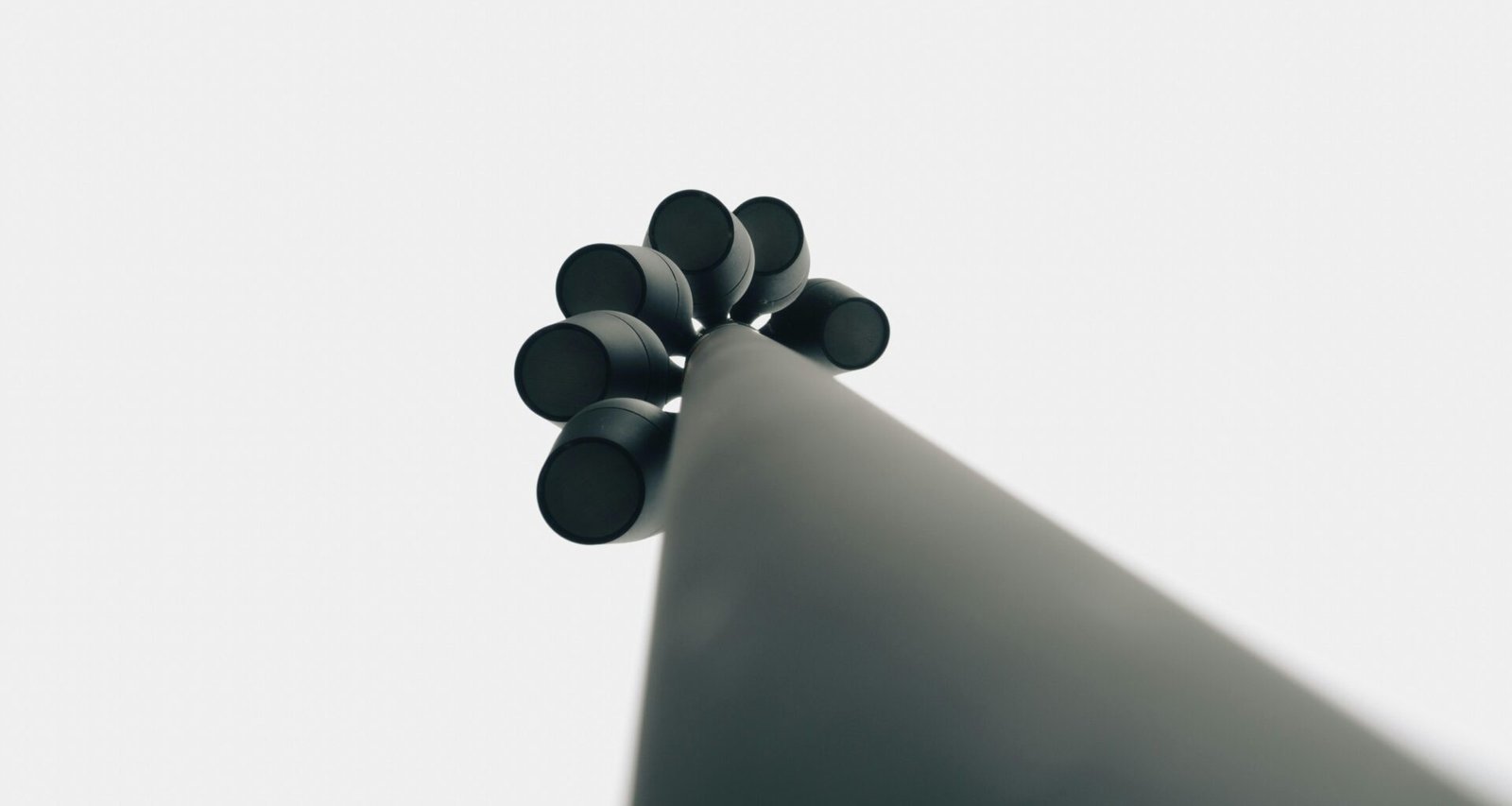 Schwarze Gegenstände platzieren sich strukturiert auf einer weißen Oberfläche in minimalistischem Stil