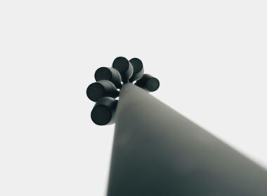 Schwarze Gegenstände liegen minimalistisch arrangiert auf einer weißen Oberfläche.