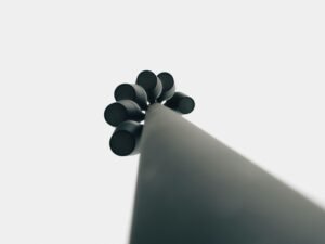 Schwarze Alltagsgegenstände liegen auf einer weißen Oberfläche und bilden einen minimalistischen Kontrast