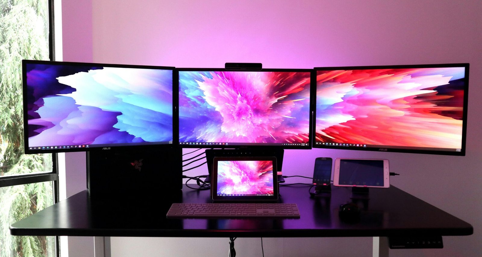 Schwarzer Flachbildfernseher platziert auf einem weißen Holzschreibtisch in einem hellen Raum.