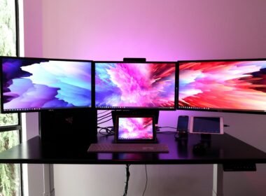 Schwarzer Flachbildfernseher platziert auf einem weißen Holzschreibtisch in einem hellen Raum.