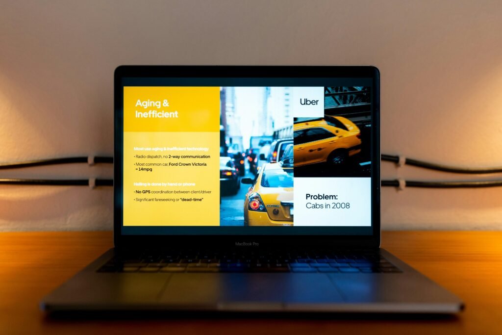 Geöffneter Laptop auf einem Schreibtisch, Bildschirm zeigt einen Mann im gelben Hemd bei einer Online-Präsentation.