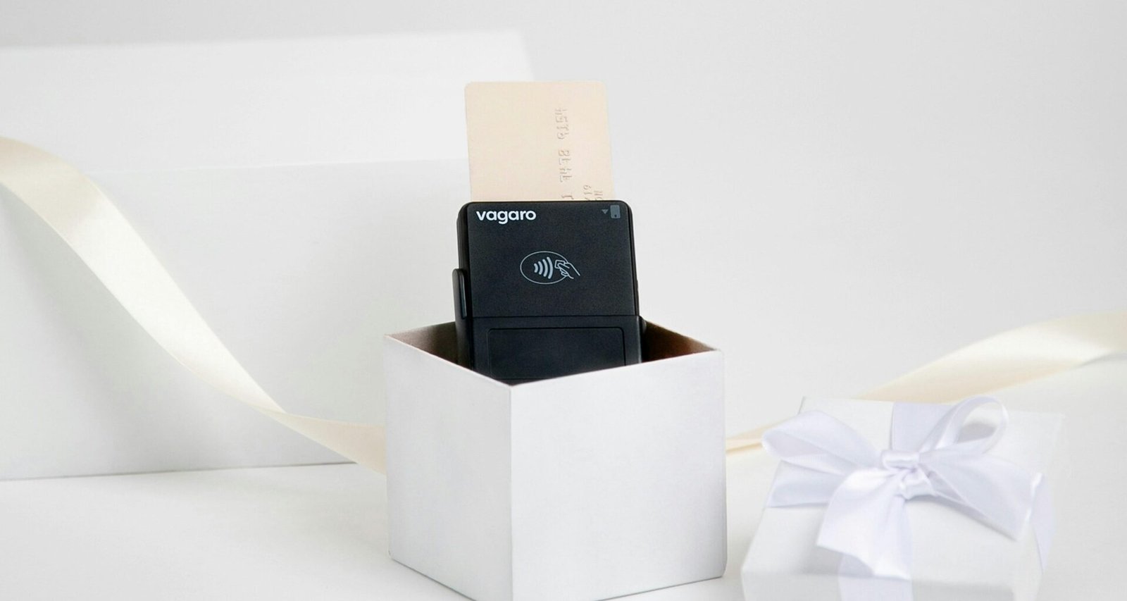 Schwarzes technisches Gerät in weißer Geschenkbox mit Schleife auf hellen Hintergrund, ideal für Produktpräsentationen