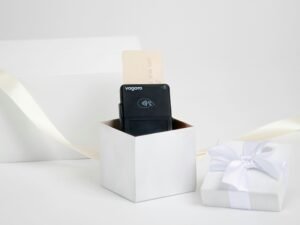 Schwarzes technisches Gerät in weißer Geschenkbox mit Schleife auf hellen Hintergrund, ideal für Produktpräsentationen