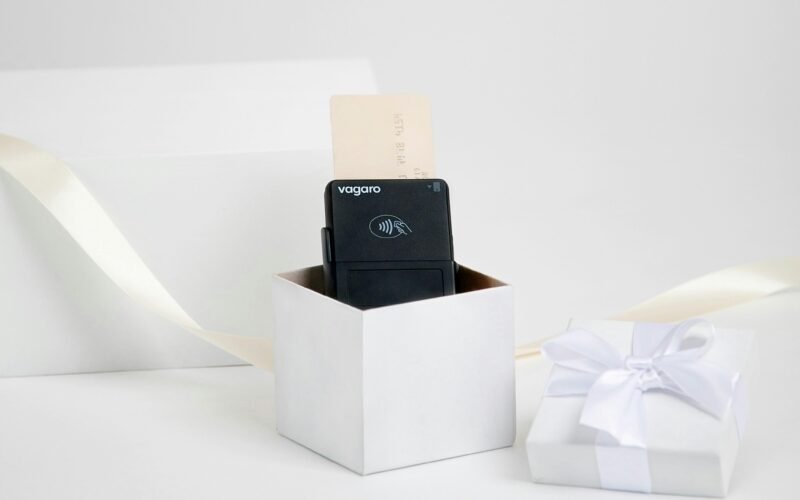 Schwarzes technisches Gerät in weißer Geschenkbox mit Schleife auf hellen Hintergrund, ideal für Produktpräsentationen