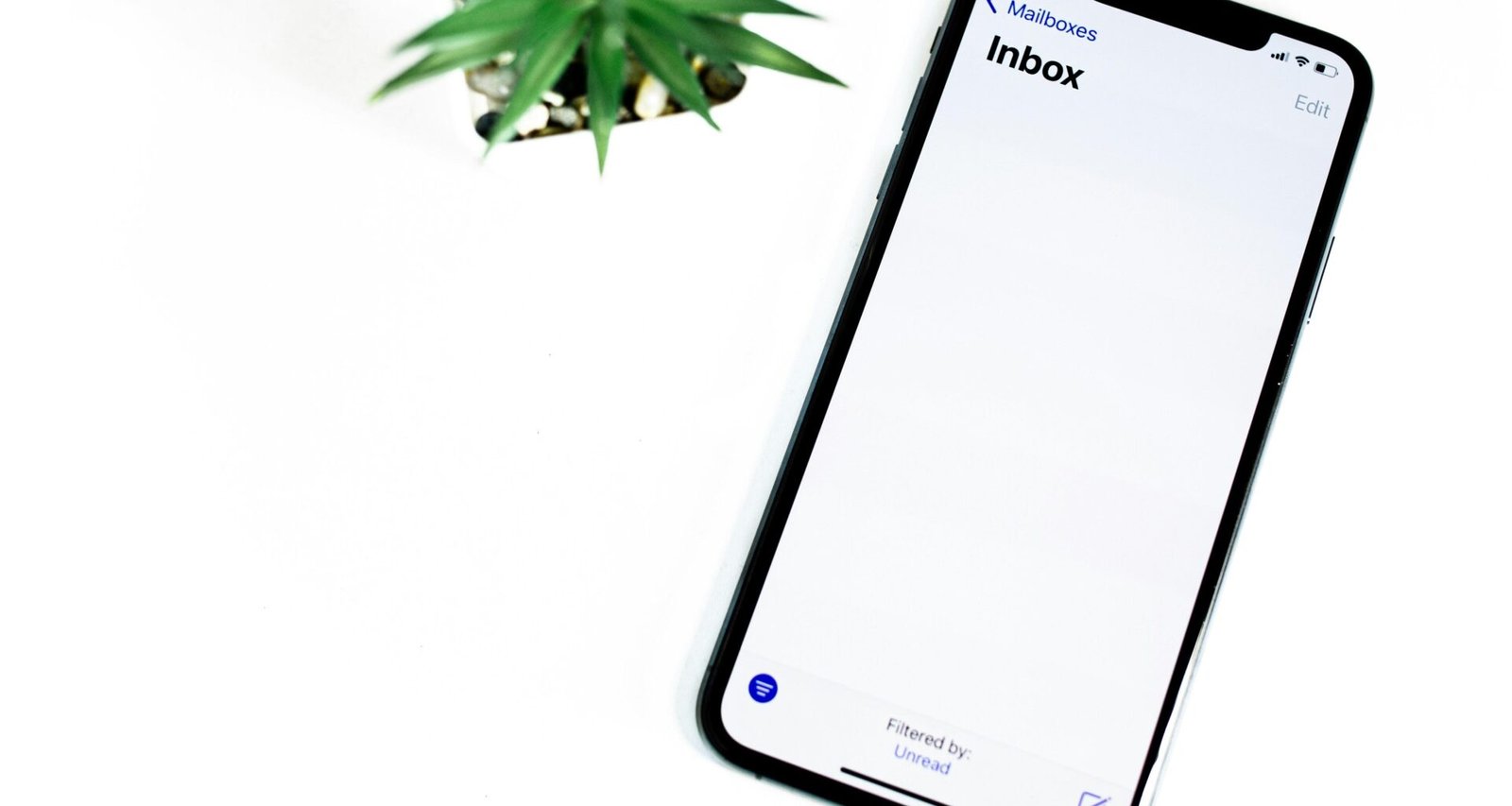 Schwarzes iPhone 5 liegt auf einer glatten weißen Oberfläche, das Gerät ist zentral ausgerichtet und gut beleuchtet