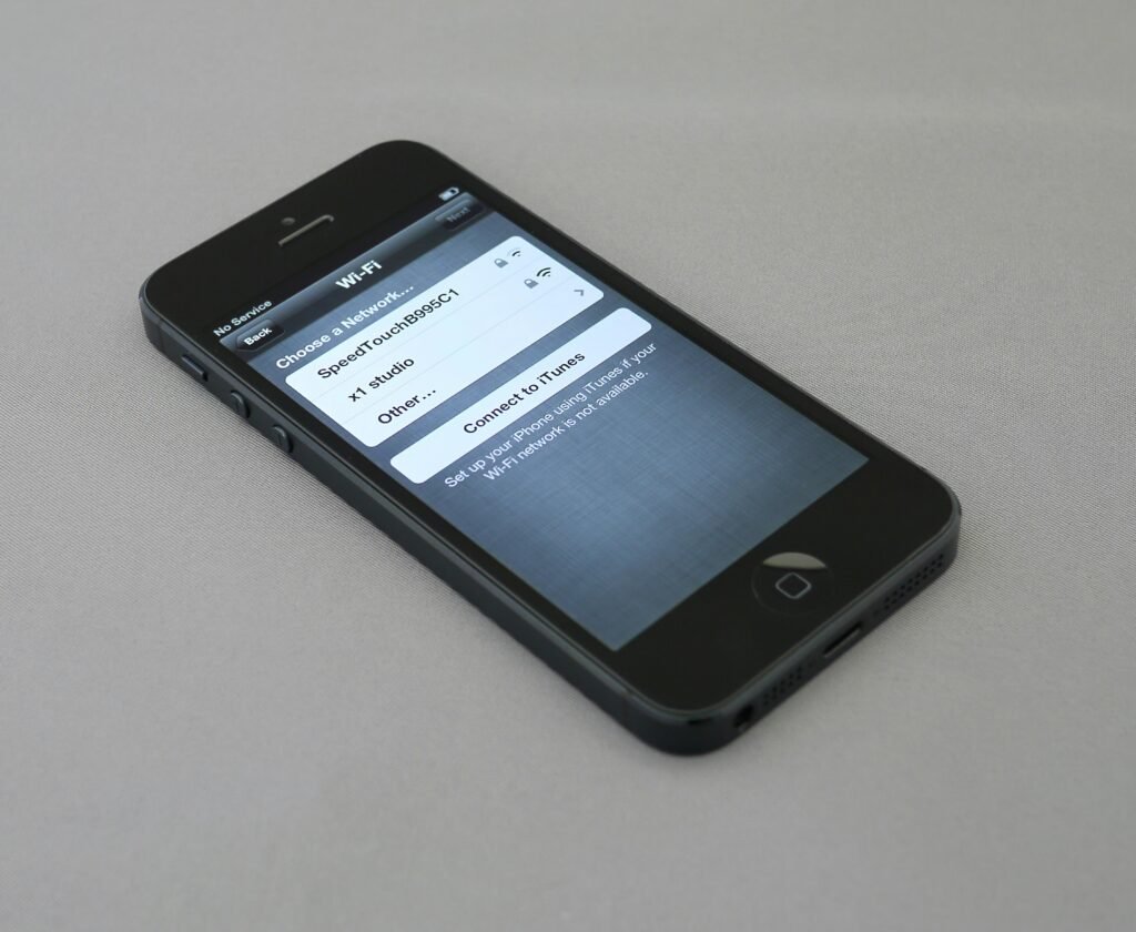 Schwarzes iPhone 5 in Nahaufnahme, liegend auf einer Oberfläche, aufgenommen von Brett Jordan