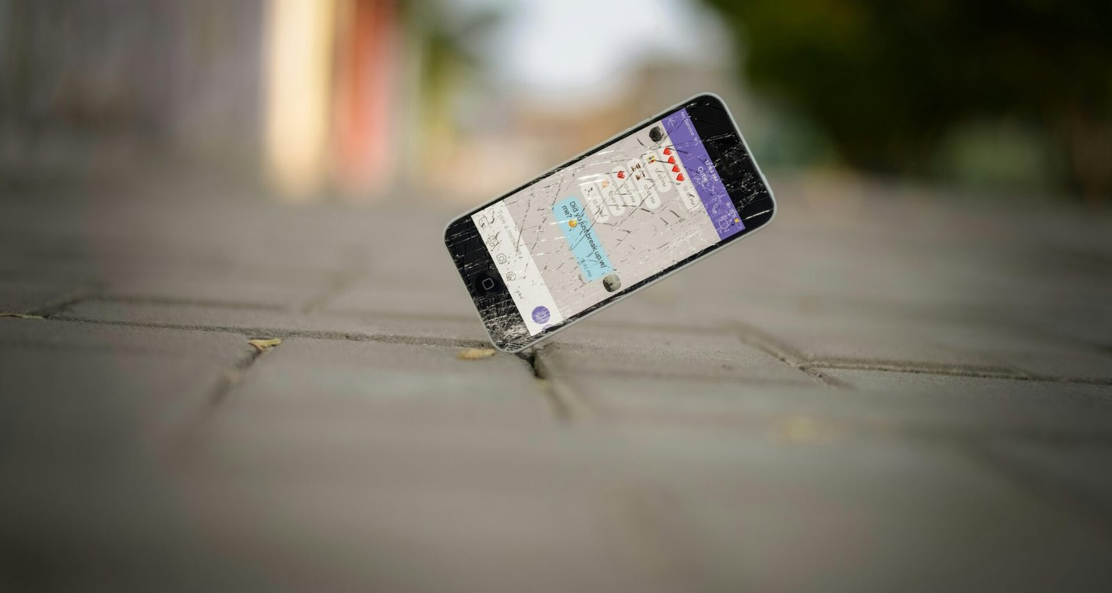 Selektive Aufnahme eines iPhones, das auf Backsteinpflaster balanciert. Perfektes Motiv für Technik-Beiträge