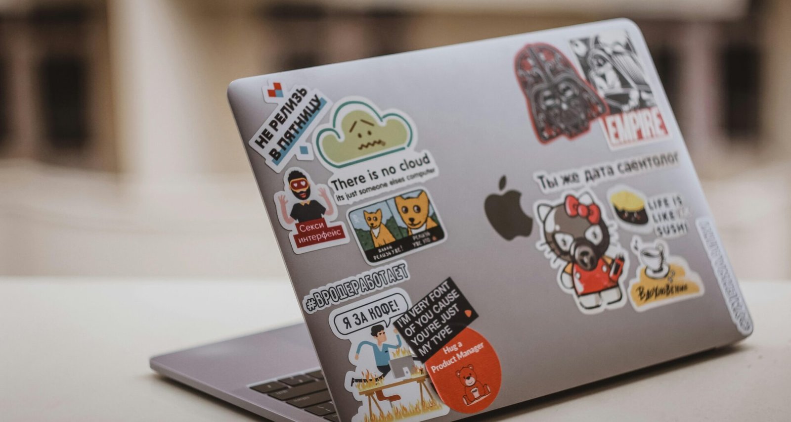 Silbernes MacBook auf einem weißen Tisch mit minimalistischem Setup, ideal für produktives und modernes Arbeiten im Büro oder Homeoffice