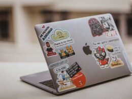 Silbernes MacBook auf einem weißen Tisch mit minimalistischem Setup, ideal für produktives und modernes Arbeiten im Büro oder Homeoffice